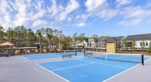 view of tennis court with fence and community basketball court
