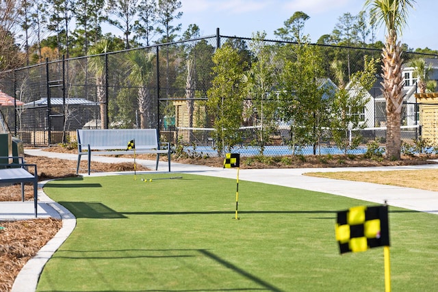 view of home's community featuring fence and a putting green