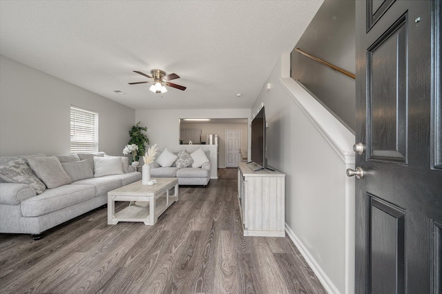 1219 Bradley Blvd, Summerville, SC 29486 - living room featuring dark wood-type flooring, a ceiling fan, stairway, baseboards, and a textured ceiling
