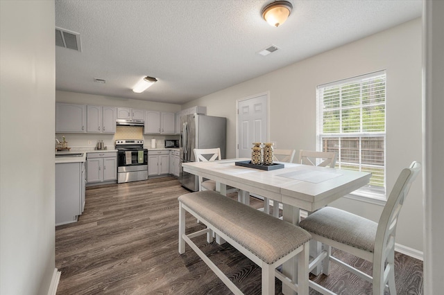 1219 Bradley Blvd, Summerville, SC 29486 - dining space with dark wood-style floors, a textured ceiling, and baseboards