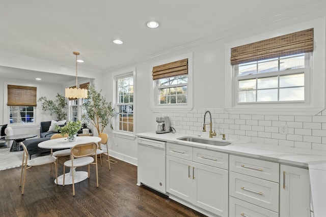 kitchen with backsplash, decorative light fixtures, dishwasher, white cabinets, and sink