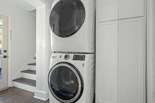 clothes washing area with stacked washer / drying machine and dark hardwood / wood-style floors