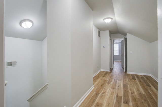 hallway featuring vaulted ceiling and light wood-type flooring