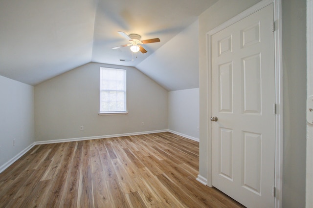 additional living space featuring light hardwood / wood-style floors, vaulted ceiling, and ceiling fan