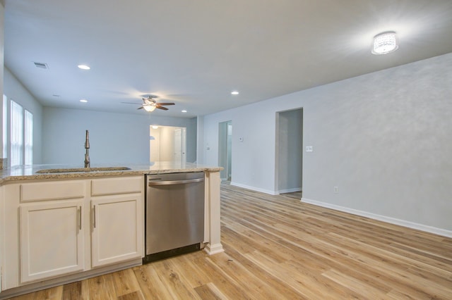 kitchen featuring ceiling fan, stainless steel dishwasher, light wood-type flooring, sink, and light stone counters