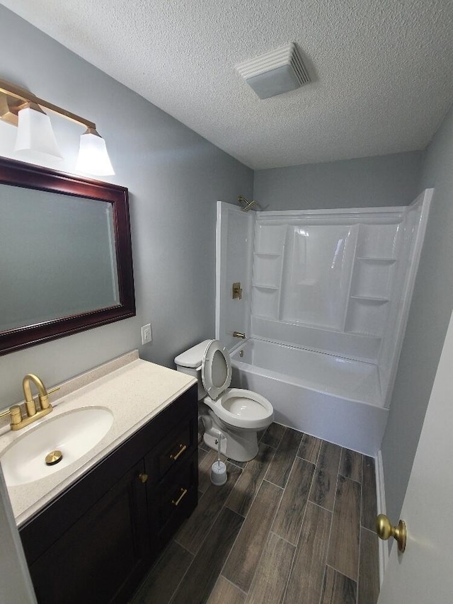 full bath featuring visible vents, toilet, wood tiled floor, tub / shower combination, and vanity