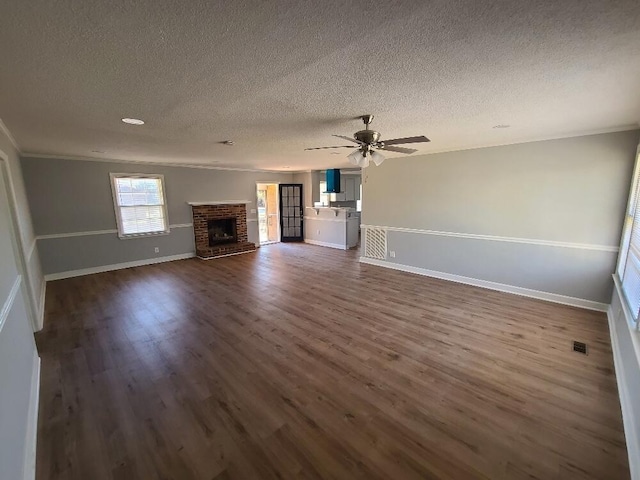 unfurnished living room with baseboards, a ceiling fan, dark wood-style floors, a textured ceiling, and a fireplace