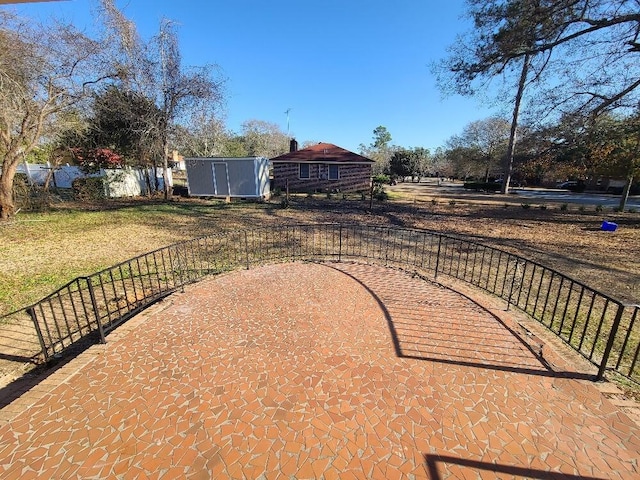 view of yard featuring a storage unit, fence, and an outdoor structure