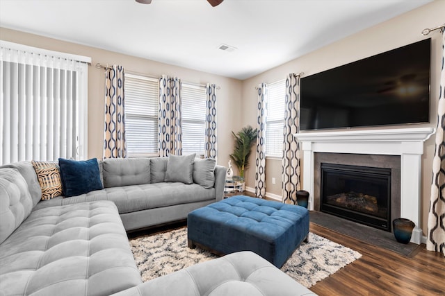 413 Ribiero Dr, Summerville, SC 29486 - living room featuring wood finished floors, visible vents, ceiling fan, baseboards, and a glass covered fireplace