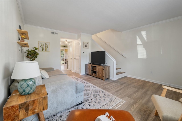 living room featuring visible vents, stairway, crown molding, and wood finished floors