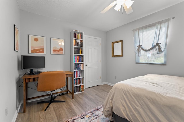 bedroom with a ceiling fan, baseboards, and wood finished floors