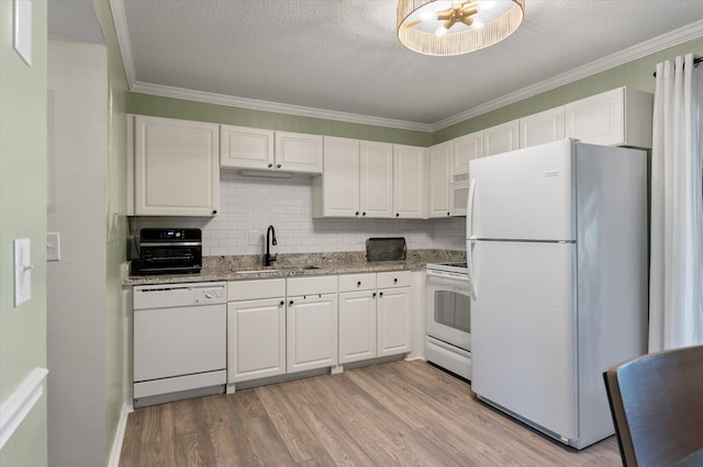 kitchen featuring a sink, white appliances, and white cabinets