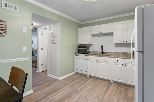 kitchen with white appliances, visible vents, a sink, white cabinets, and light wood-style floors