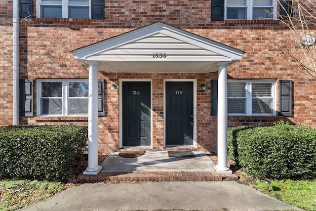 doorway to property with brick siding