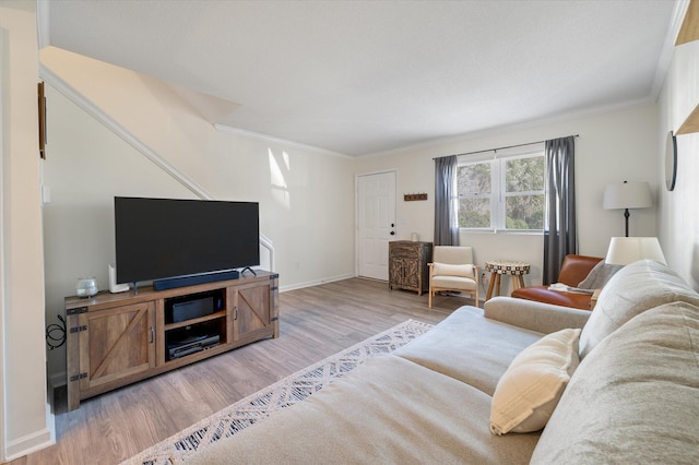 living room featuring baseboards, ornamental molding, and light wood finished floors