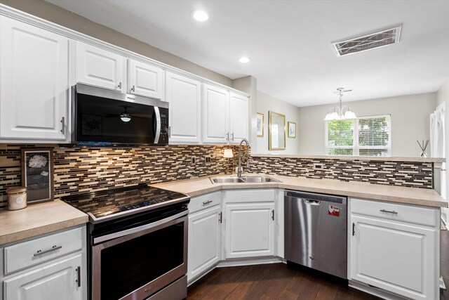8676 Grassy Oak Trl, North Charleston, SC 29420 - kitchen with stainless steel appliances, a sink, dark wood-style floors, a peninsula, and light countertops
