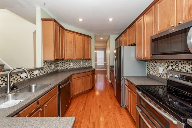 kitchen featuring backsplash, light hardwood / wood-style floors, sink, and stainless steel appliances