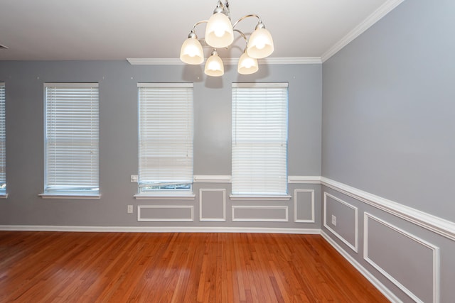 unfurnished dining area with a chandelier, hardwood / wood-style floors, and ornamental molding