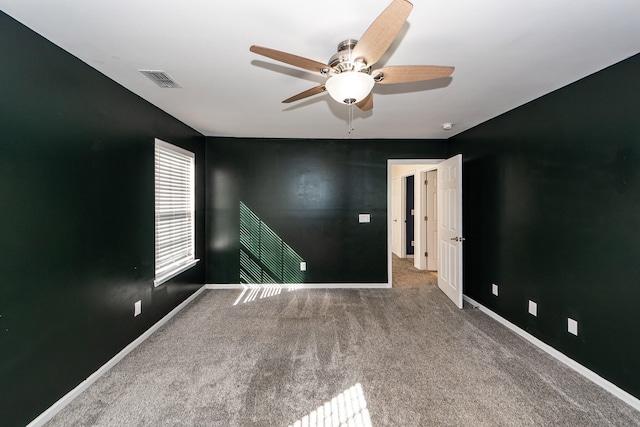 carpeted spare room with ceiling fan