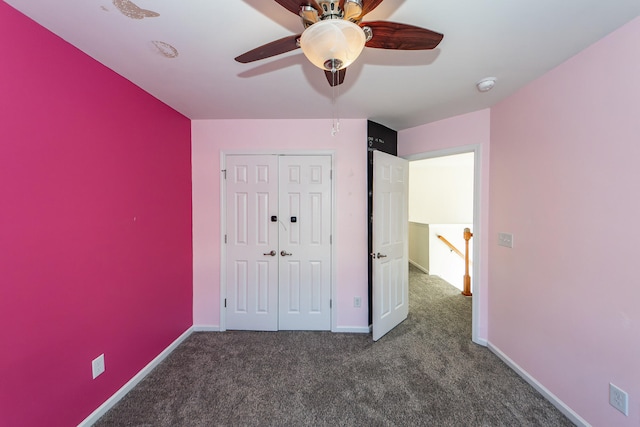 unfurnished bedroom with ceiling fan, a closet, and dark colored carpet