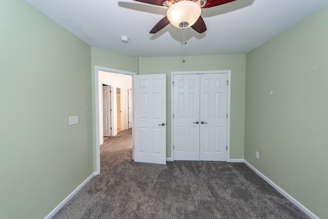 unfurnished bedroom with dark colored carpet, ceiling fan, and a closet