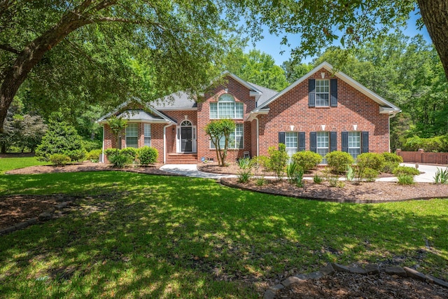 traditional-style home featuring brick siding and a front yard