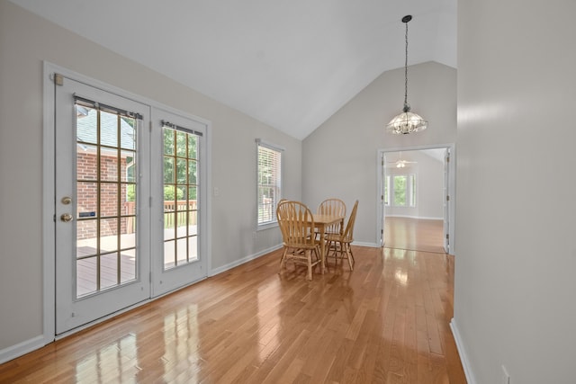 dining space with light wood-type flooring, baseboards, high vaulted ceiling, and a ceiling fan