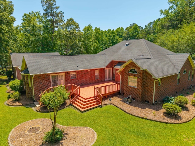 rear view of house with brick siding, a wooden deck, a yard, a shingled roof, and crawl space