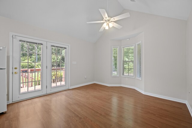 spare room with plenty of natural light, wood finished floors, a ceiling fan, and high vaulted ceiling