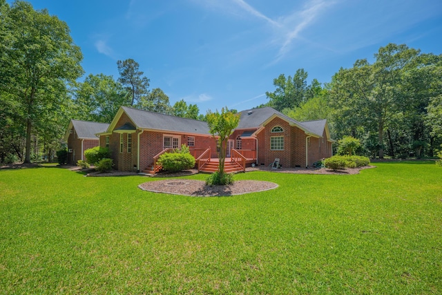 back of house featuring a wooden deck, brick siding, and a yard