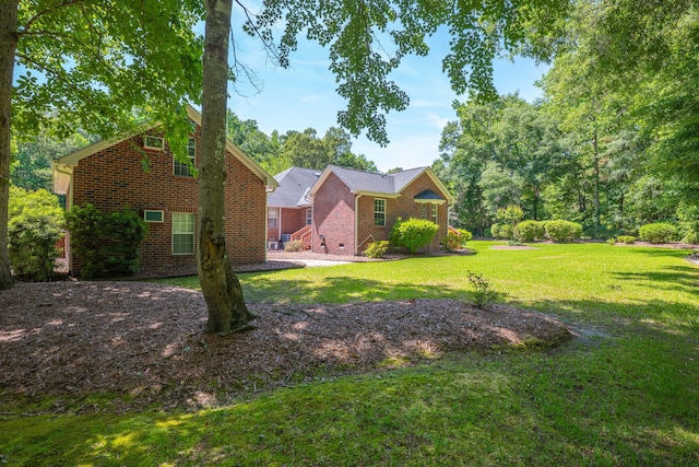view of front of home featuring brick siding and a front lawn