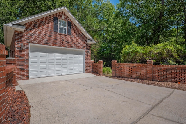 garage featuring fence and driveway