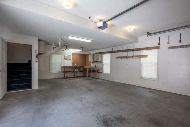 garage featuring a garage door opener and an AC wall unit