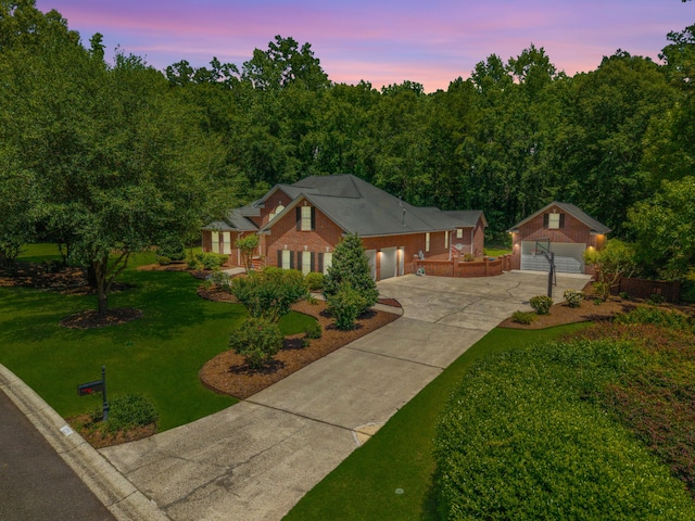 view of front of property featuring concrete driveway, brick siding, a front yard, an outdoor structure, and an attached garage
