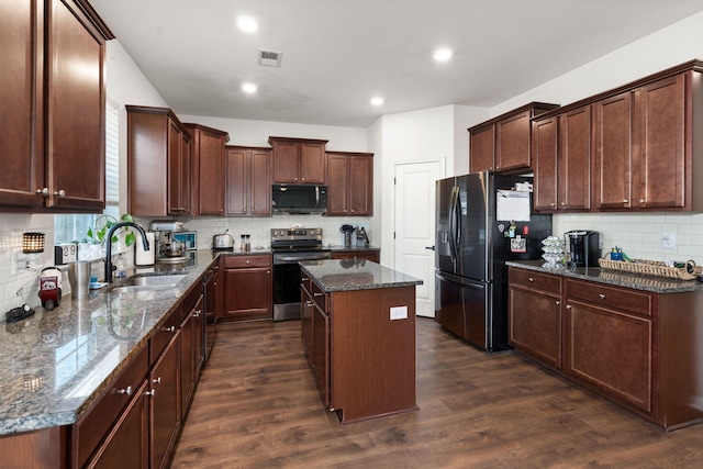 kitchen with sink, black fridge, stainless steel electric range oven, a center island, and dark stone countertops