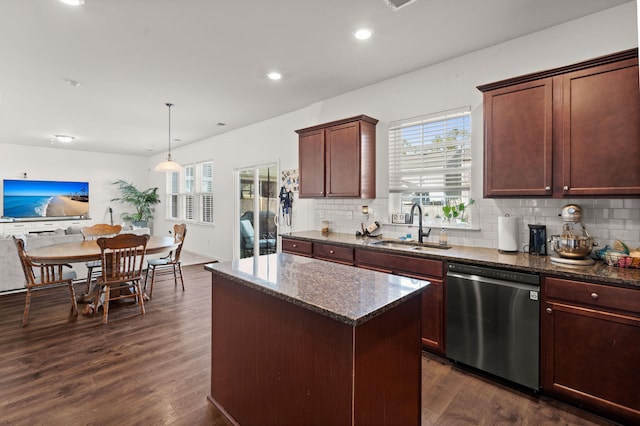 kitchen featuring dark wood-type flooring, sink, decorative light fixtures, a center island, and stainless steel dishwasher