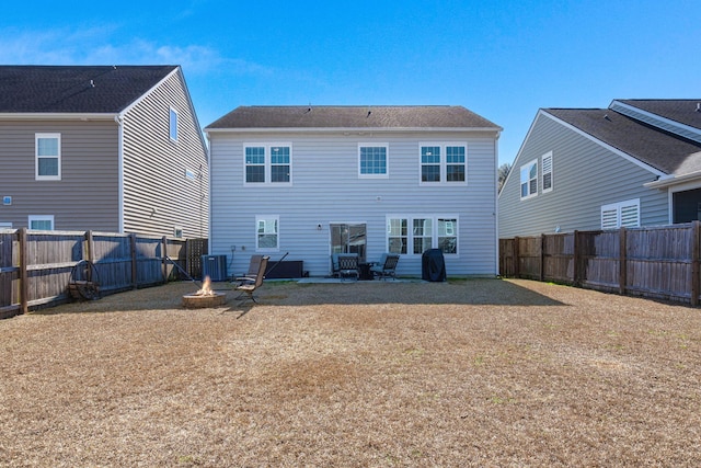 rear view of house with a patio, central air condition unit, and an outdoor fire pit