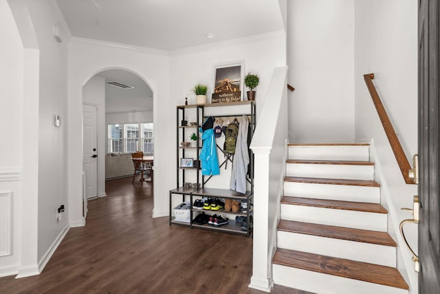 stairs featuring wood-type flooring and ornamental molding