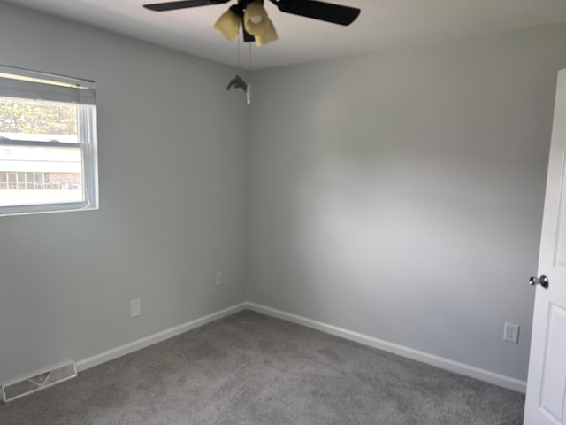 spare room with ceiling fan, visible vents, baseboards, and carpet