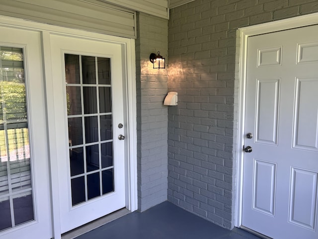 doorway to property featuring brick siding