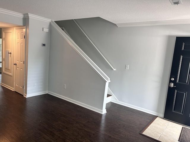 interior space with ornamental molding, dark wood-style flooring, a textured ceiling, and stairway