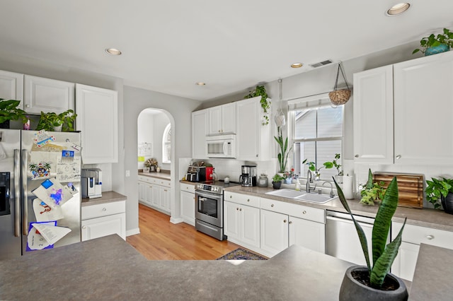 kitchen featuring sink, white cabinets, light wood-type flooring, and stainless steel appliances