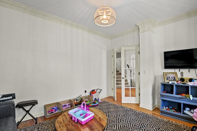 game room featuring crown molding, hardwood / wood-style flooring, and a chandelier