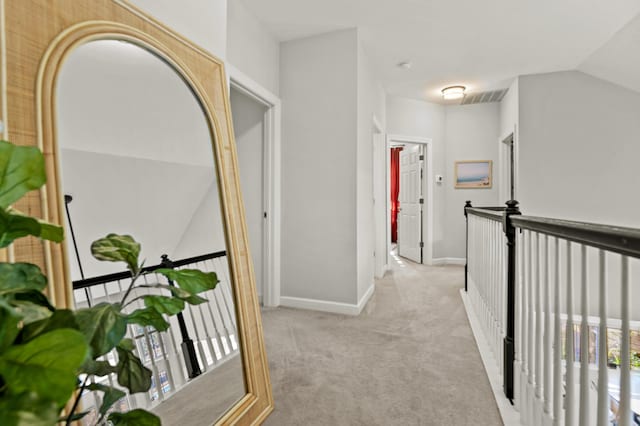 hallway with light colored carpet and vaulted ceiling