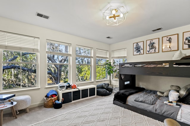 bedroom with light carpet and an inviting chandelier