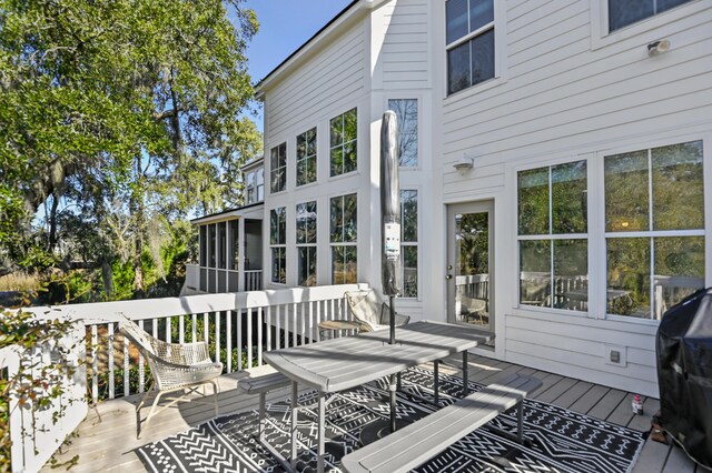 wooden terrace with a grill and a sunroom