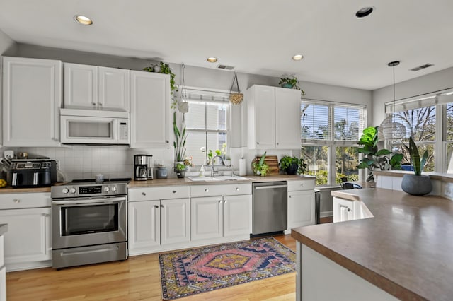 kitchen featuring white cabinets, appliances with stainless steel finishes, and sink