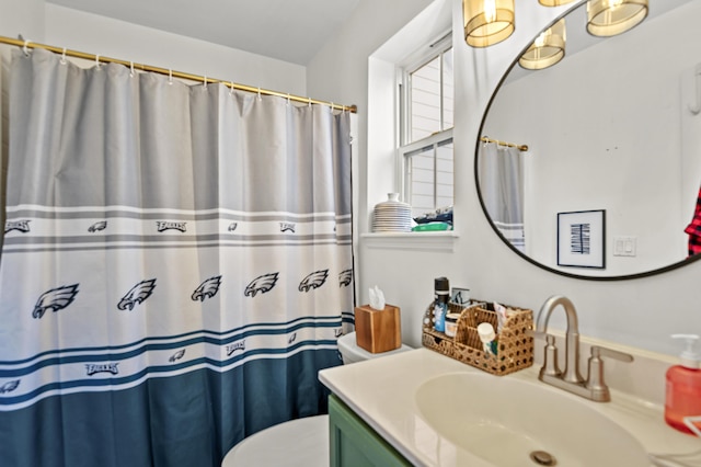 bathroom featuring toilet, vanity, and walk in shower