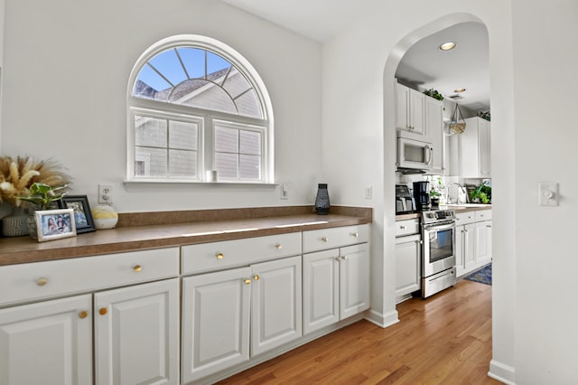 kitchen featuring sink, white cabinetry, light hardwood / wood-style floors, and stainless steel electric range oven