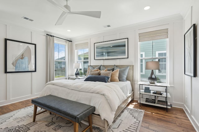 bedroom featuring dark wood-type flooring, ceiling fan, and ornamental molding